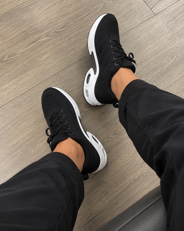 The black shoes seen from above on a wooden floor