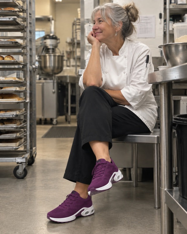 A baker resting in the kitchen in the purple shoes